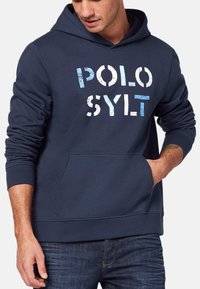 Marinblå hoodie med en framficka, med texten "POLO SYLT" i slitna vita och ljusblå bokstäver. Tillverkad av mjukt bomullsmaterial.