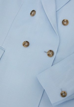 Svetlomodré dvojradové sako so zlatými gombíkmi a golierom s výrezom, zobrazujúce detaily prednej časti a rukávov.