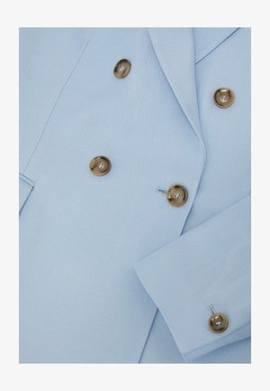 Sacou dublu cu două rânduri de nasturi de culoare albastru deschis, cu nasturi aurii și rever cu tăietură în formă de creastă, prezentând detalii frontale și la mâneci.