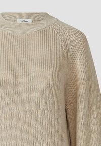 Beżowy sweter dzianinowy o ribbed texture, z okrągłym dekoltem i raglanowymi rękawami. Posiada małą metkę z nazwą marki "s.Oliver."