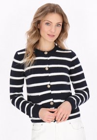 Cardigan a righe blu marino e bianche realizzato in morbido tessuto a maglia, con scollo rotondo, bottoni frontali e polsini a coste.