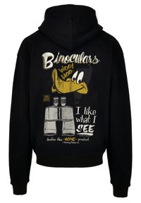 Felpa nera con cappuccio caratterizzata da un design grafico con un'anatra dei cartoni animati, binocoli e testo che dice "Mi piace ciò che VEDO", in giallo e bianco.