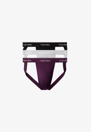 Drie Calvin Klein heren jockstraps in zwart, wit en donkerpaars met gebrande taillebanden, verticaal gestapeld op een witte achtergrond.