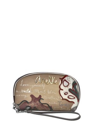 Pequeña bolsa para muñeca beige con patrones abstractos en rojo y verde, logo dorado "Anekke" y texto inspirador manuscrito en la parte delantera.