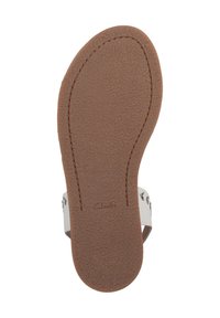 Suela de goma marrón con acabado texturizado, que presenta un diseño de correa blanca y una paleta de colores neutra, mostrando el logo de la marca "Clarks."