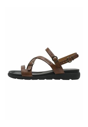 Brown leather sandal with a flat black rubber sole, featuring cross straps and adjustable buckles. Smooth texture and minimalist design.