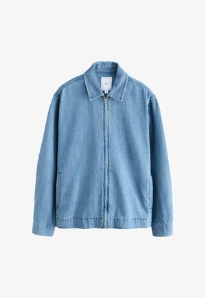 Hele sinine teksajakk, millel on tõmblukk esifaas, terav krae ja kaks küljetaskut. Omab lõdva lõikega ja pehmet tekstuuri.