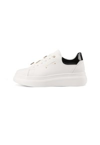 Sneaker bianco con accenti in pelle verniciata nera, punta rotonda, hardware dorato sui lacci, suola piattaforma e branding in rilievo sul lato.