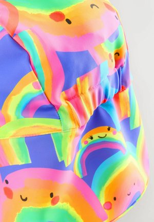 Spalvinga medžiaga su šypsenčiomis vaivorykštėmis rožinės, oranžinės, žalios ir mėlynos spalvų. Dizainas apima surinktas akcentus ir lygią tekstūrą.