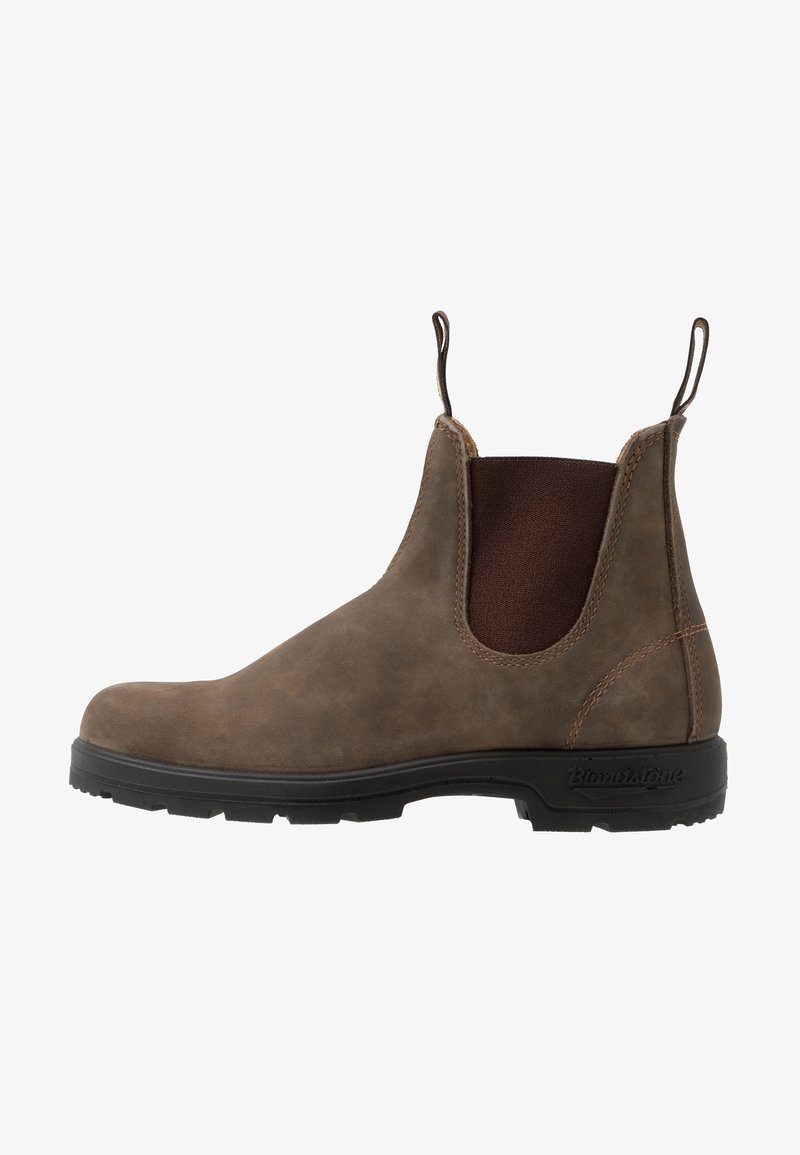 Bottine Chelsea en cuir marron avec semelle noire, panneau latéral élastique, et languettes de traction à l'avant et à l'arrière.