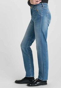 Jean en denim bleu clair avec une coupe droite, fermeture à bouton en métal, deux poches avant et une poche arrière avec un détail brodé.