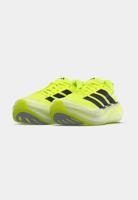 Neon yellow athletic shoes with black accents, featuring a streamlined design, textured mesh upper, and a thick, white midsole.