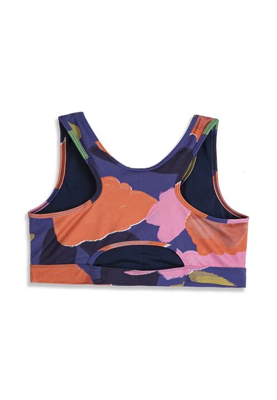 Brassière de sport avec larges bretelles et découpe dans le dos, présentant un motif floral abstrait en violet, orange, rose et vert sur fond blanc.