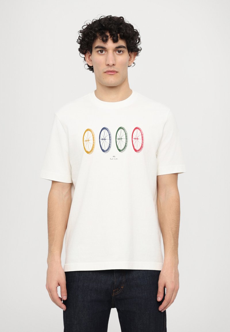 Bela bombažna majica z kratkimi rokavi, ki ima na sredini natisnjen vzorec štirih koles koles v rumeni, modri, zeleni in rdeči barvi.