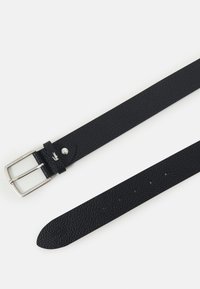 Ceinture en cuir noir avec une surface texturée, boucle rectangulaire en argent et plusieurs trous pour l'ajustement. Présente un petit détail de logo.