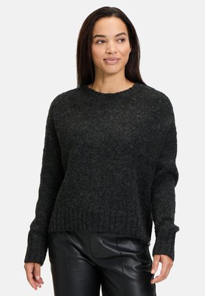 Dunkelgrauer gestrickter Pullover mit Rundhalsausschnitt und geripptem Saum, ausgestattet mit langen Ärmeln und strukturiertem Finish, kombiniert mit schwarzen Lederhosen.