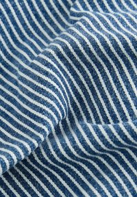 Blau-weißer gestreifter Stoff mit strukturiertem Gewebe, das ausgeprägte horizontale Linien und einen sanften Fall zeigt.