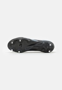 Sole di scarpini da calcio neri con tacchetti sollevati e superficie texture; presenta strisce blu lungo i lati.