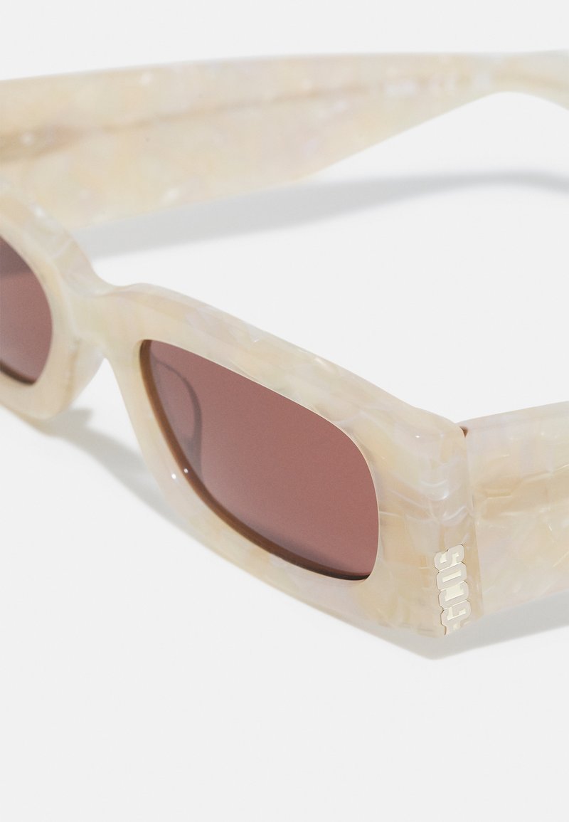 Translucent light beige sunglasses with rectangular frames, featuring brown lenses and textured, marbled finish. Logo on the side.