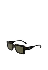 Lunettes de soleil en forme carrée avec une épaisse monture en écaille de tortue et des verres sombres. Les branches noires arborent un logo en blanc. Texture lisse sur l'ensemble.