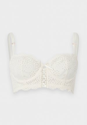 Hvid blonde balconette-bh med justerbare stropper, bølgede kanter og en lille sløjfedetalje foran i midten.