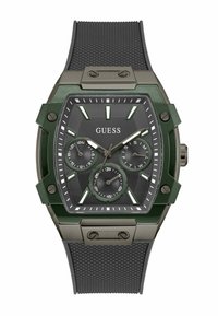 Montre verte et noire en forme hexagonale, avec un bracelet en caoutchouc noir texturé, trois sous-cadrans et des index horaires proéminents. Détails en métal.