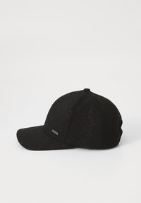 Schwarze Baseballmütze mit strukturiertem Muster und gebogenem Schirm. Enthält ein kleines metallisches Logo-Highlight an der Seite.