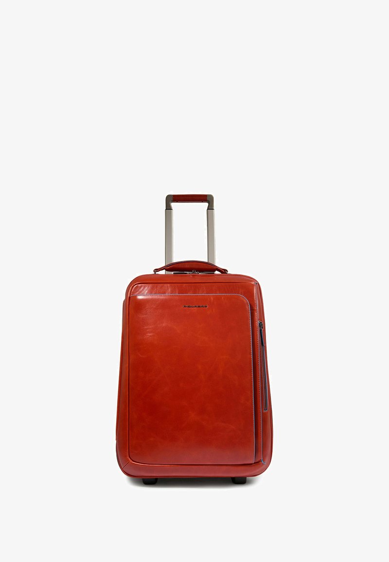 Rode leren koffer met een gestructureerde afwerking, intrekbare handgreep, bovenhandgreep en een zijzak met rits. Stevige bodem met wieltjes.
