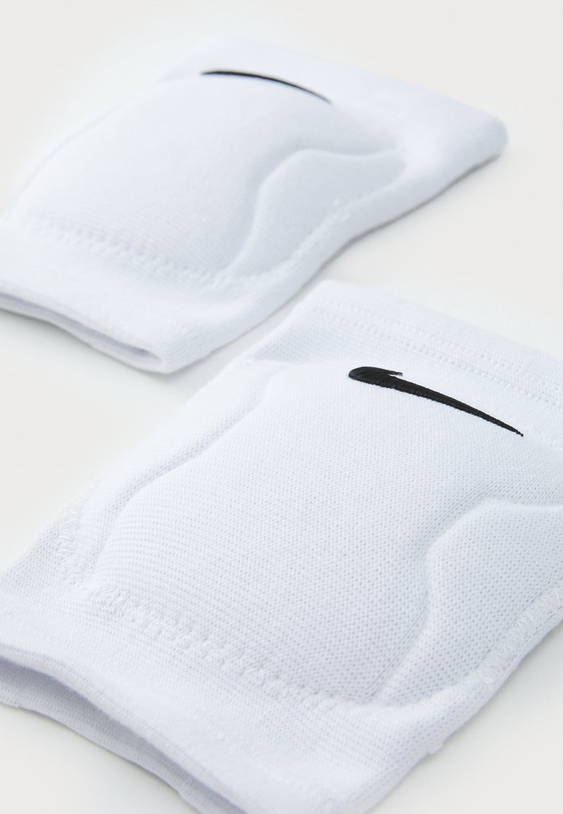 Witte gewatteerde kniemouwen van textiel met een gestructureerde stof, met op elke knie sleeve een zwart Nike swoosh logo. Compact ontwerp voor steun en bescherming.
