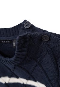Maglione lavorato a maglia blu navy con un motivo testurizzato, caratterizzato da un colletto a coste e due bottoni neri all'apertura del collo.