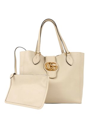 Sac cabas en cuir beige avec double poignée, fermoir logo double-G doré et pochette zippée assortie détachable.