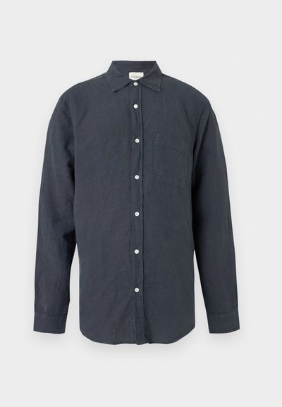 Σκούρο γκρι πουκάμισο με μακριά μανίκια, κουμπιά, γιακά και μία τσέπη στο στήθος, παρουσιάζεται σε απλό ανοιχτό φόντο.