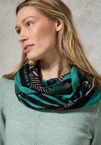 Sciarpa infinita multicolore realizzata in tessuto morbido. Presenta motivi a righe turchesi e nere con accenti bianchi e beige.