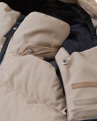 Beżowa ocieplana kurtka z zamkiem błyskawicznym z przodu, napami i wieloma kieszeniami. Posiada fakturowany materiał i kontrastową ciemną podszewkę.