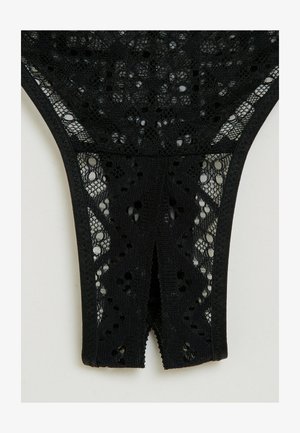 String nero in pizzo con motivo floreale, dettaglio con taglio sul retro e vita elastica. Texturizzato con lavorazione in pizzo intricata.