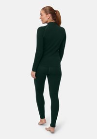 Dark green fitted thermal set featuring a long-sleeve top with a high collar and matching leggings. Soft texture, seamless design.