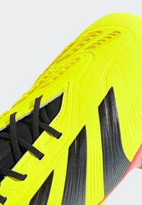 Scarpino da calcio giallo brillante con accenti neri, tomaia sintetica testurizzata, design con strisce audaci e lacci neri per una vestibilità sicura.
