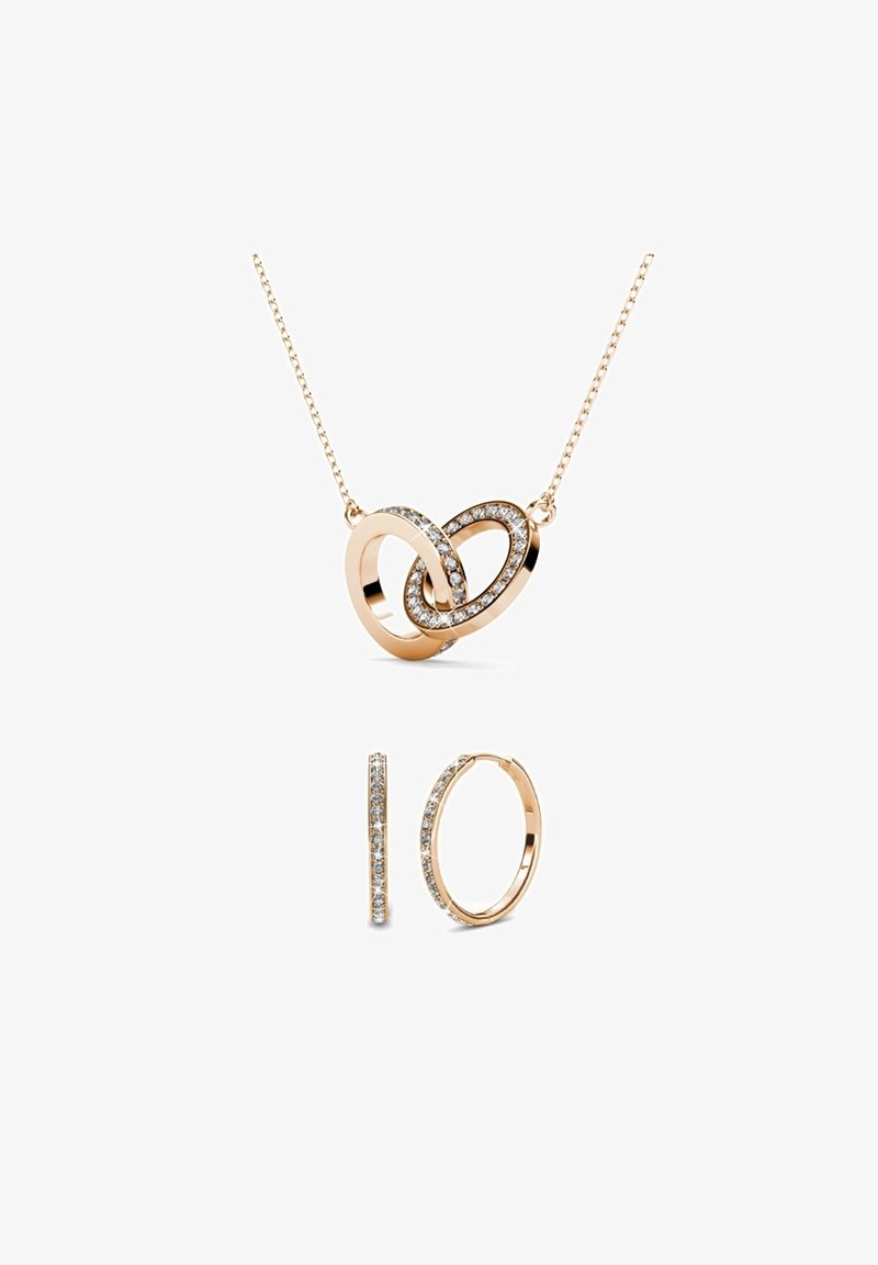 Set di gioielli in oro rosa composto da un pendente a forma di cuore con pietre chiare e orecchini a cerchio abbinati con una sola fila di pietre chiare.