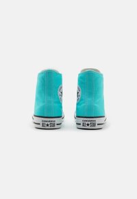 Sneakers alte in tela turchese con suole in gomma nera, caratterizzati da cuciture bianche e logo Chuck Taylor sul lato esterno.