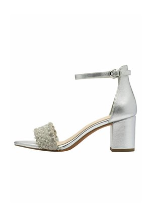 Sandale argentée à talon avec un bout carré. Comprend une bride tressée ornée d'accents métalliques et une bride de cheville à boucle.