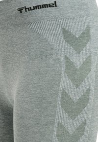 Grå sporttights med en strukturerad mönster på sidan, med en mörkare grön chevrondesign. Logotypen är tryckt vid midjan.