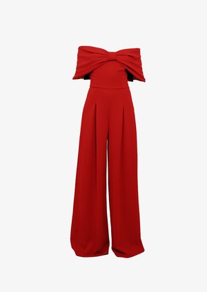 Rdeča breznaramna kombinacija z velikim lokom čez prsi in širokimi hlačami.