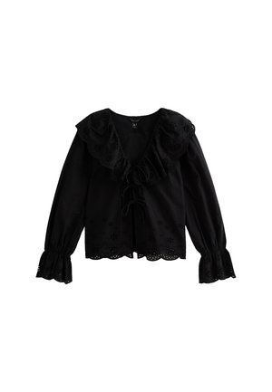 Blouse noire à manches longues avec un col à volants, un devant à cordon et des découpes florales brodées le long de l'ourlet et des manches.