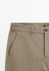 Khaki bukser med en glat overflade, med lige pasform, side lommer, bæltestropper og en enkelt knaplukning.