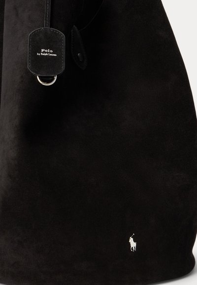 Μαύρη καστόρινη τσάντα Polo από Ralph Lauren με μικρό λευκό λογότυπο παίκτη πόλο κοντά στο κάτω μέρος και μαύρη δερμάτινη ετικέτα με το όνομα της μάρκας.