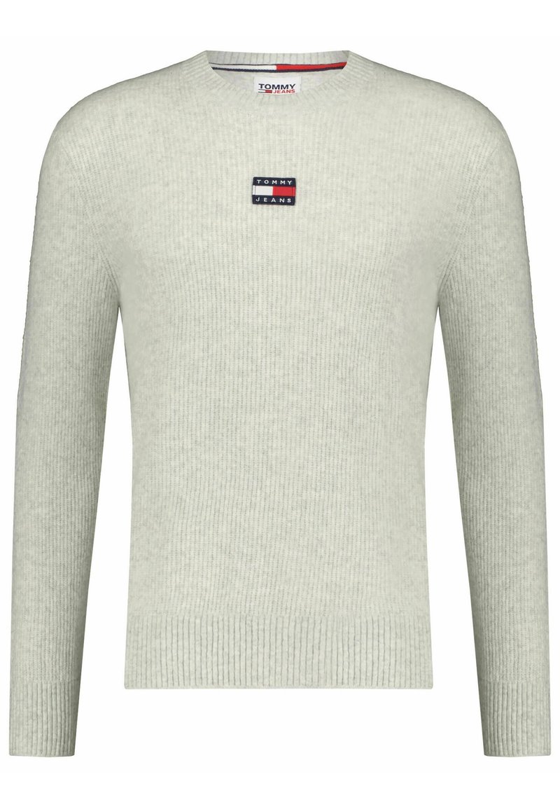 Světle šedý žebrovaný svetr s kulatým výstřihem. Obsahuje malou nášivku s logem Tommy Jeans na hrudi. Měkká, strukturovaná tkanina.