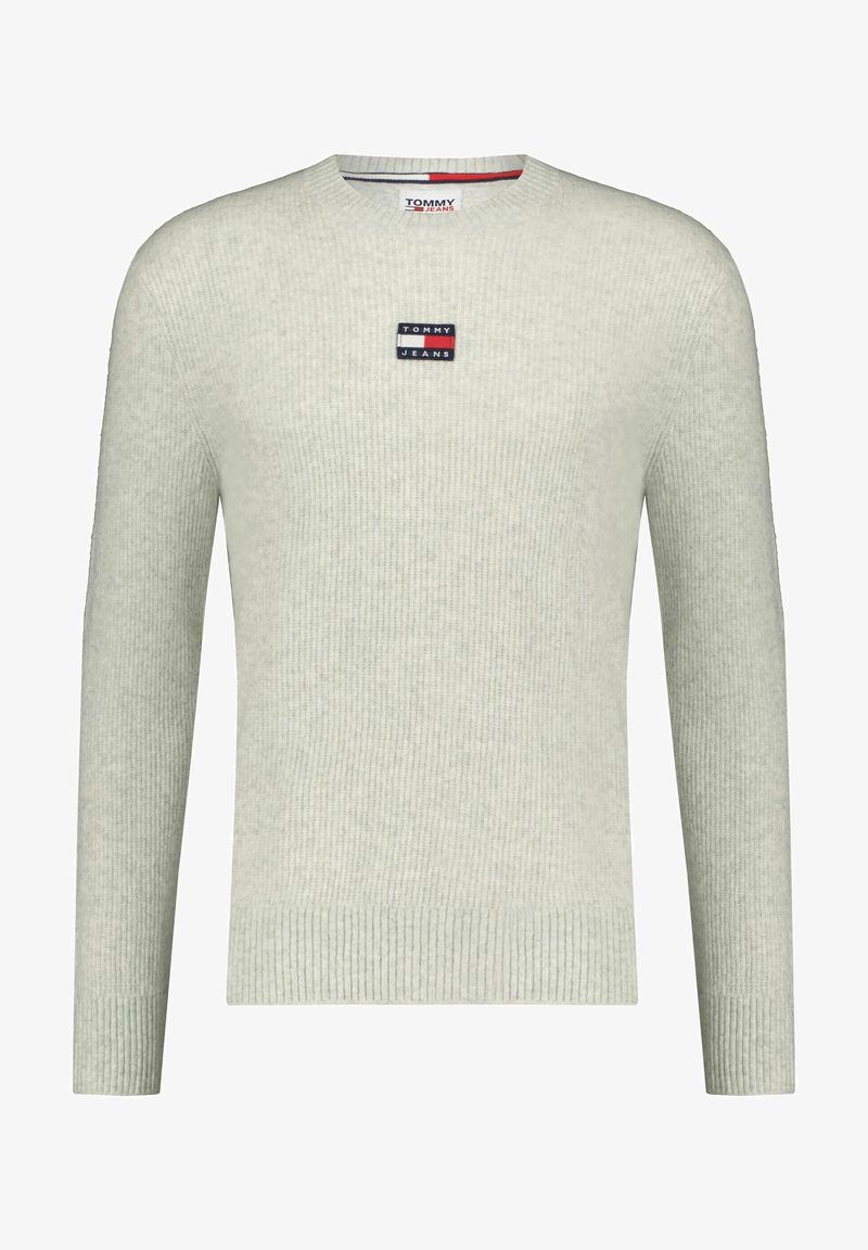 Světle šedý žebrovaný svetr s kulatým výstřihem. Obsahuje malou nášivku s logem Tommy Jeans na hrudi. Měkká, strukturovaná tkanina.