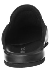 Sorte slip-on sko med rund tådesign, glat læderoverflade, polstret indre og flad gummisål. Ingen synlig hardware.