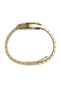 Montre-bracelet dorée avec un bracelet en métal ondulé, boîtier circulaire et verre lisse à l'avant. Dispose d'une couronne texturée sur le côté.