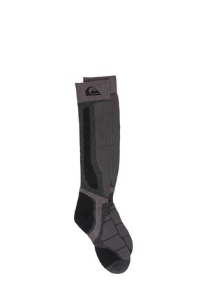 Paire de longues chaussettes de sport grises et noires avec zones rembourrées et logo sur le haut du bord-côte, sur fond blanc.
